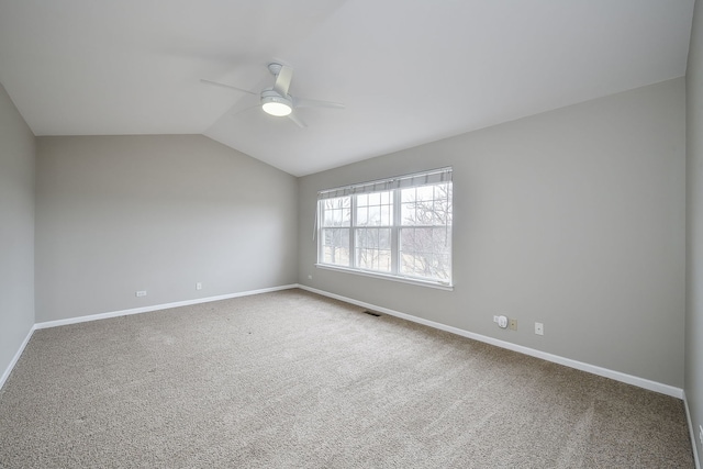 carpeted empty room featuring visible vents, baseboards, vaulted ceiling, and a ceiling fan