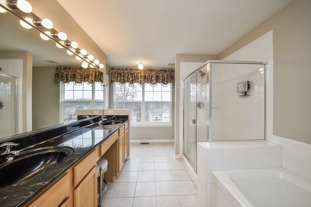 full bathroom with a stall shower, double vanity, a sink, and tile patterned floors