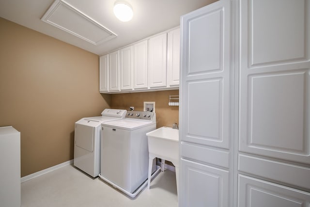 washroom featuring attic access, baseboards, cabinet space, and washing machine and clothes dryer