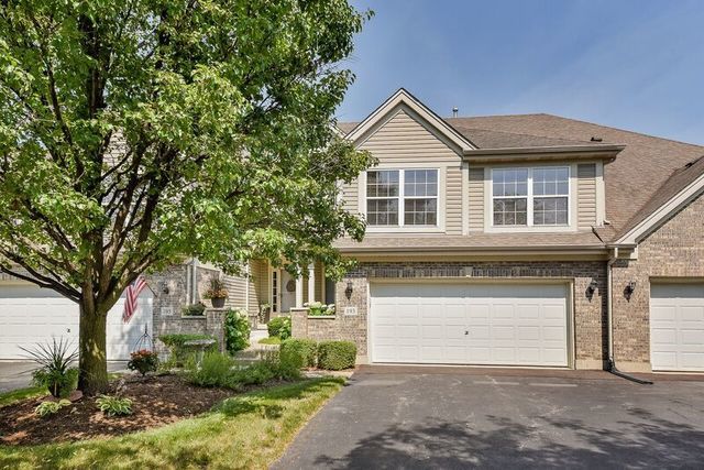 view of front of property featuring driveway, a garage, and brick siding