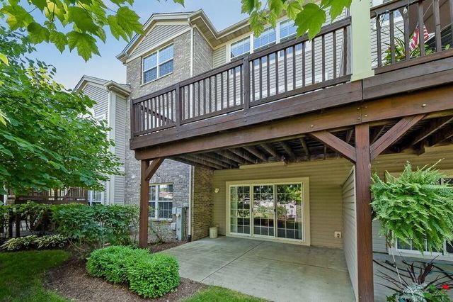 rear view of house with brick siding, a deck, and a patio