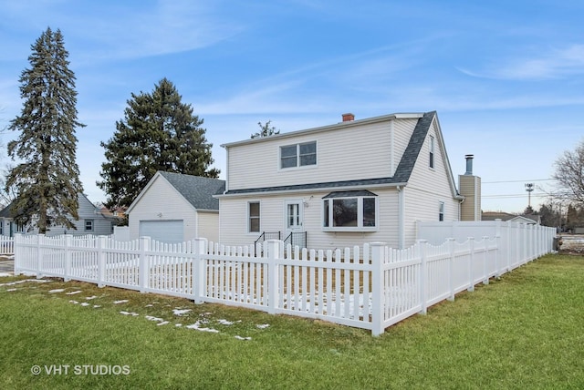 view of front of home featuring a fenced front yard, a detached garage, an outdoor structure, and a front yard