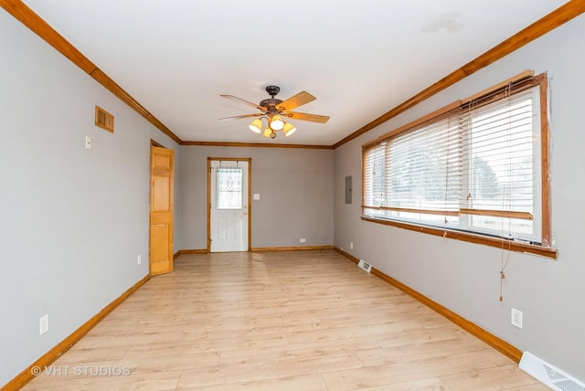 unfurnished room featuring light wood finished floors, visible vents, and ornamental molding