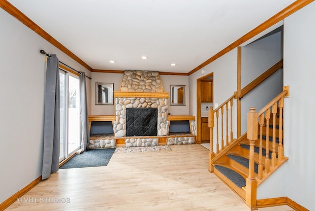 living area featuring crown molding, a fireplace, wood finished floors, and baseboards