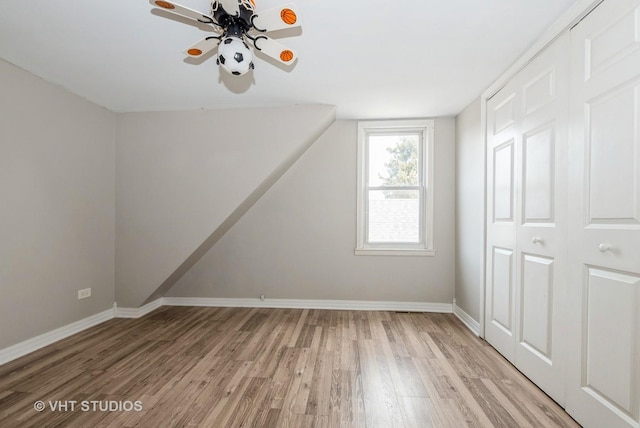 bonus room with light wood-style floors, ceiling fan, and baseboards