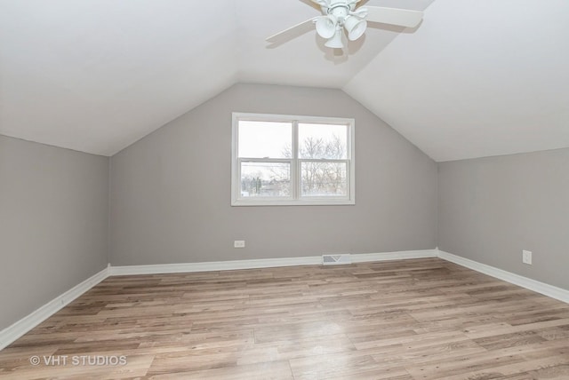 additional living space featuring lofted ceiling, light wood-style floors, baseboards, and visible vents