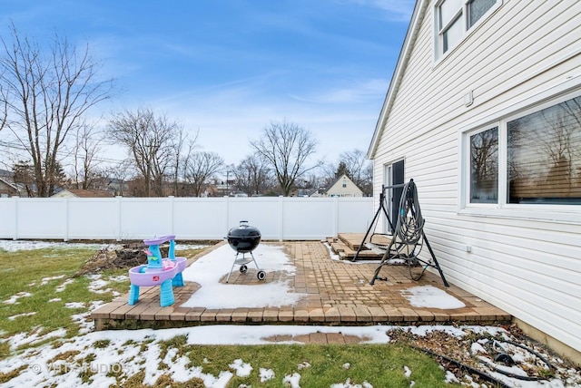 yard covered in snow with a patio area and a fenced backyard