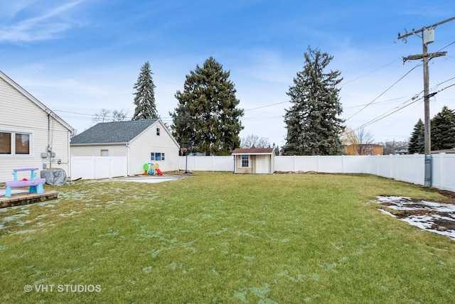 view of yard with an outbuilding, a fenced backyard, and a storage unit