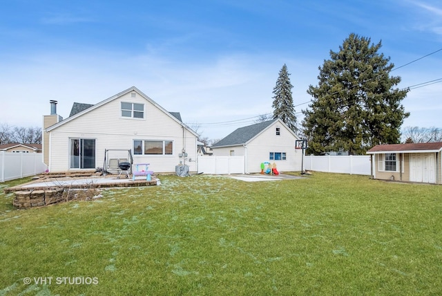 back of property with a yard, a fenced backyard, a patio, and an outdoor structure