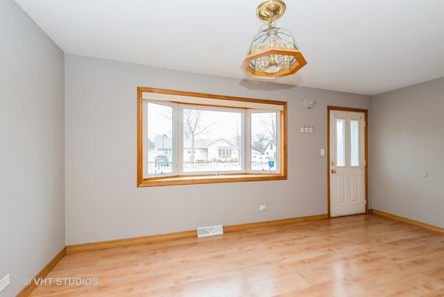 interior space featuring baseboards, visible vents, and wood finished floors