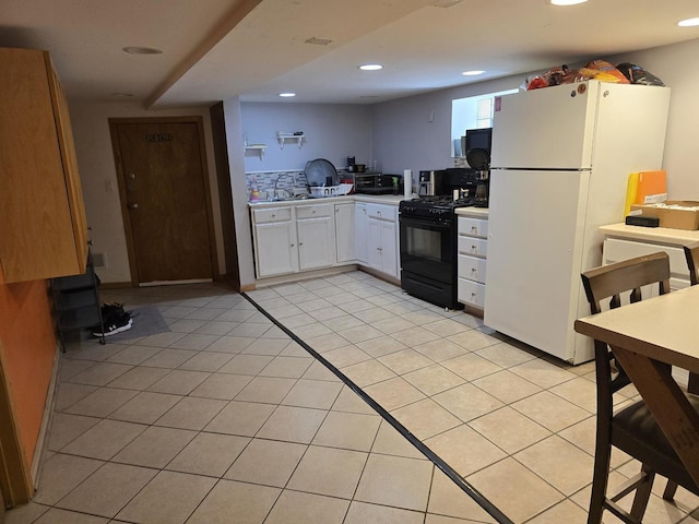 2320 W Addison St, Chicago, IL 60618 - kitchen featuring light tile patterned floors, white cabinetry, light countertops, freestanding refrigerator, and gas stove