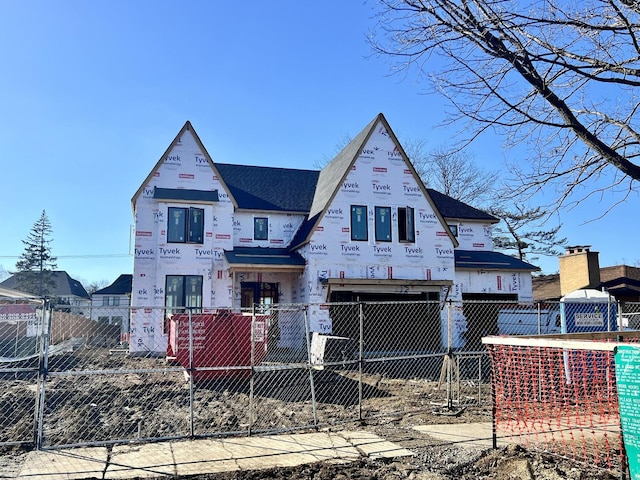 unfinished property featuring an attached garage, driveway, and a fenced front yard