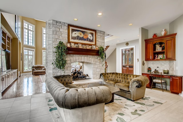 living room with light tile patterned floors, built in desk, and a fireplace