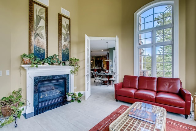 living room with a high ceiling and a high end fireplace