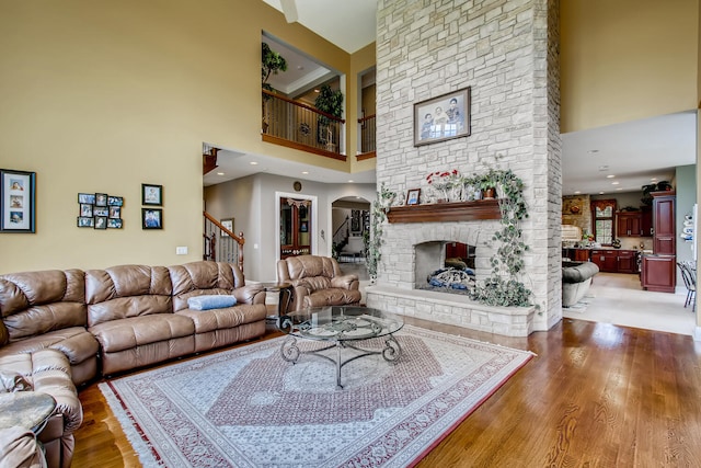 living room with a fireplace, hardwood / wood-style floors, and a high ceiling