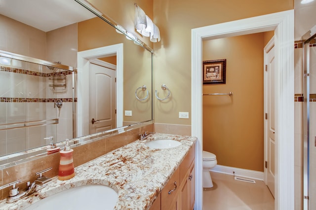 bathroom with vanity, toilet, and a shower with shower door