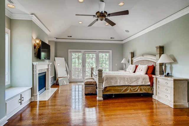 bedroom featuring hardwood / wood-style flooring, ornamental molding, vaulted ceiling, and ceiling fan