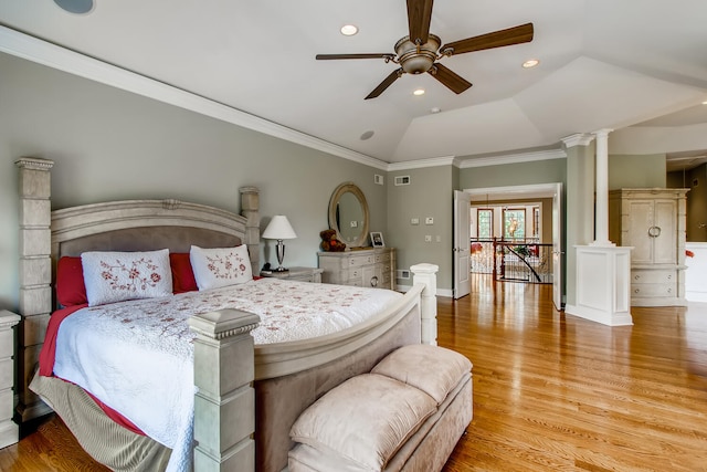 bedroom with light hardwood / wood-style flooring, ornate columns, vaulted ceiling, and ornamental molding