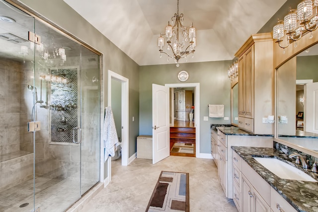 bathroom with lofted ceiling, a chandelier, vanity, and a shower with door