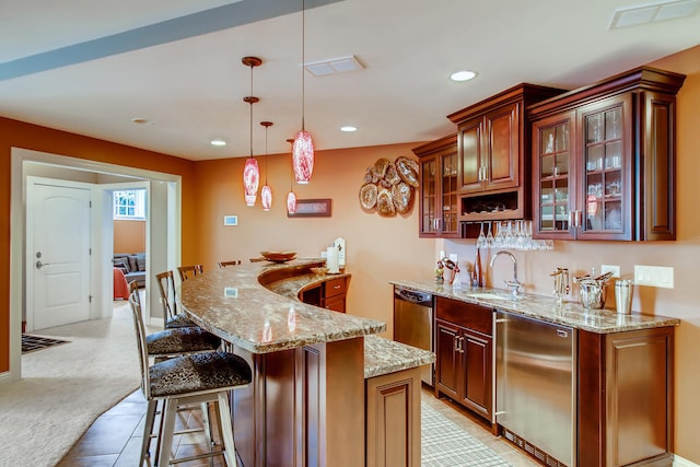 kitchen with refrigerator, sink, a kitchen island, decorative light fixtures, and stainless steel dishwasher