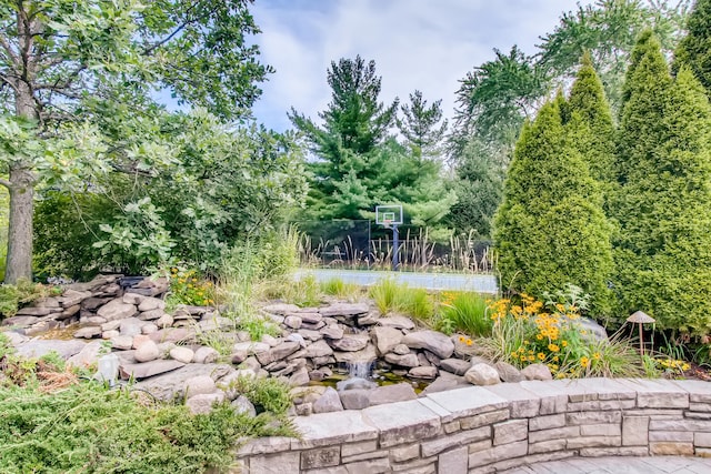 view of yard featuring basketball hoop