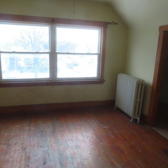 bonus room with radiator, plenty of natural light, hardwood / wood-style floors, and lofted ceiling