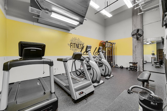 workout area featuring a towering ceiling