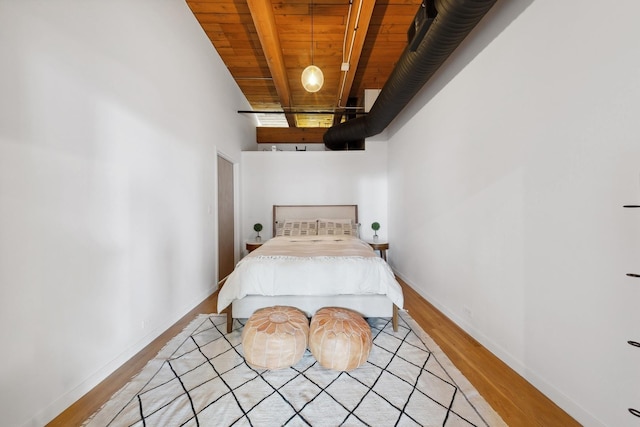 bedroom with light wood-style floors, wood ceiling, baseboards, and beamed ceiling