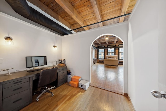 home office with wooden ceiling, light wood-style flooring, arched walkways, and beam ceiling