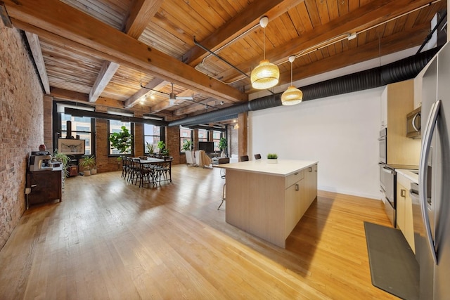 kitchen featuring wooden ceiling, stainless steel microwave, light wood-style flooring, and brick wall