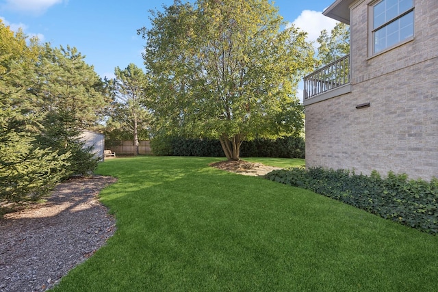 view of yard with fence and a balcony