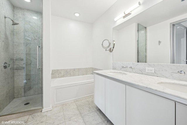 bathroom with a garden tub, double vanity, a stall shower, and a sink