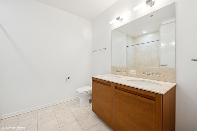 full bathroom featuring double vanity, tiled shower, a sink, and toilet