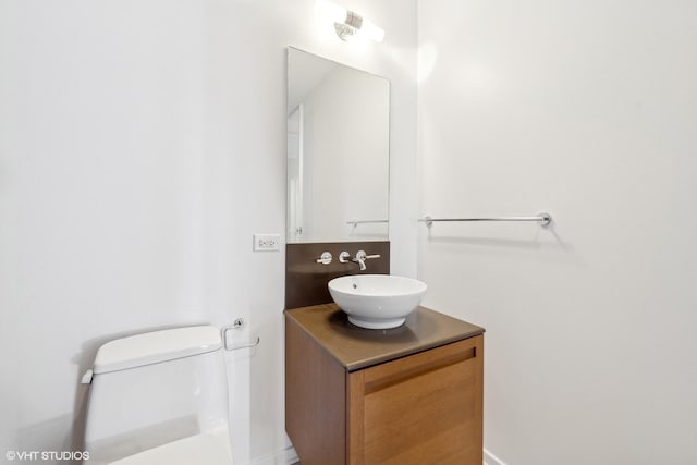 half bathroom with toilet and vanity