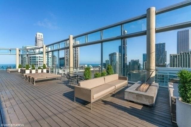 deck featuring a city view and an outdoor living space with a fire pit