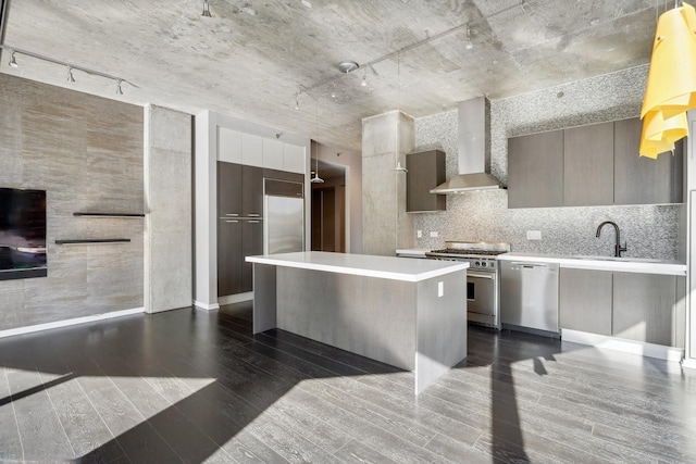 kitchen featuring wall chimney range hood, modern cabinets, stainless steel appliances, and light countertops