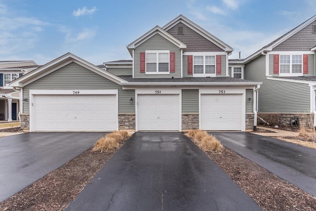 view of front of home with driveway and stone siding