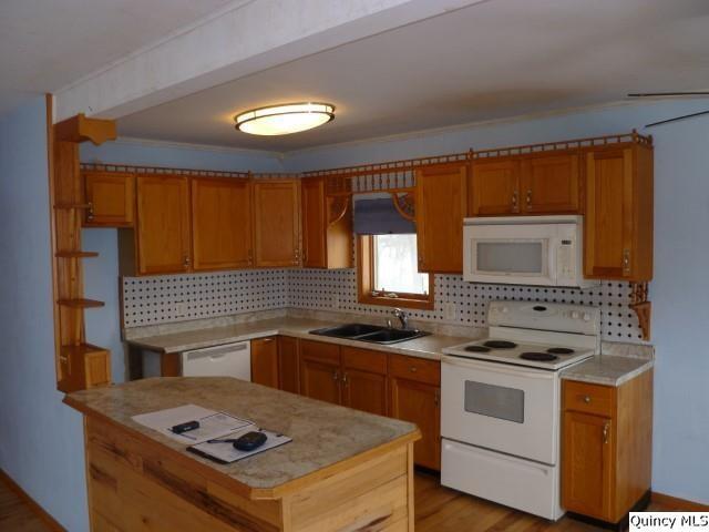 kitchen featuring sink, white appliances, tasteful backsplash, and light hardwood / wood-style floors