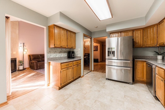 7914 S Garfield Ave, Burr Ridge, IL 60527 - kitchen with appliances with stainless steel finishes, brown cabinetry, backsplash, and a fireplace