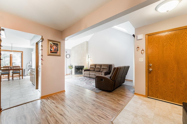 7914 S Garfield Ave, Burr Ridge, IL 60527 - entryway with a fireplace, vaulted ceiling, and light wood-style floors