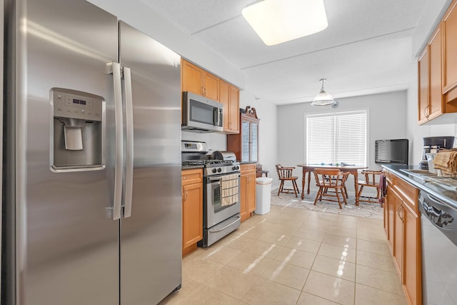 kitchen featuring light tile patterned floors, stainless steel appliances, and pendant lighting