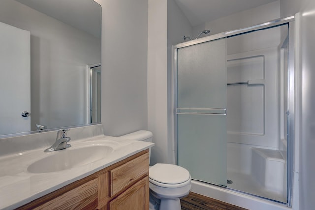 bathroom with toilet, a shower with door, and vanity