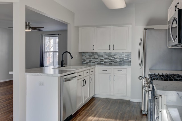 kitchen with appliances with stainless steel finishes, sink, white cabinetry, and kitchen peninsula