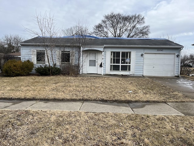 single story home with concrete driveway and an attached garage