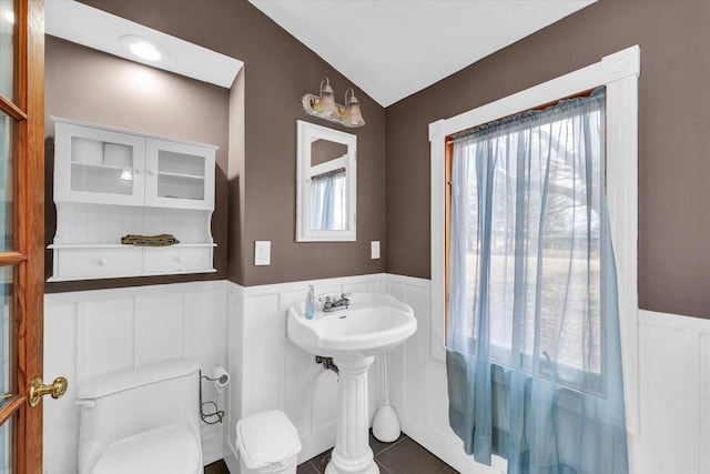 half bath featuring toilet and wainscoting