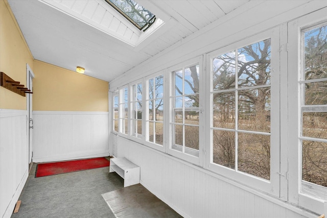 unfurnished sunroom featuring lofted ceiling with skylight and a healthy amount of sunlight