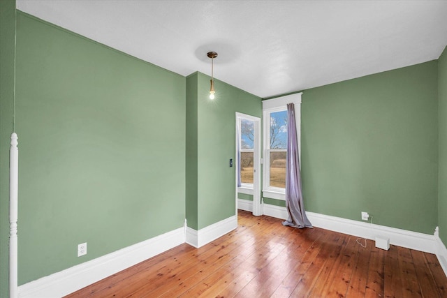 empty room featuring baseboards and hardwood / wood-style flooring