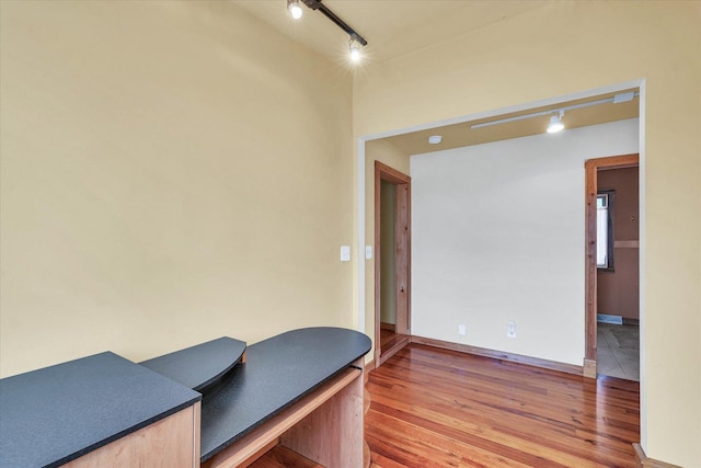 office area featuring baseboards, light wood-style flooring, and track lighting