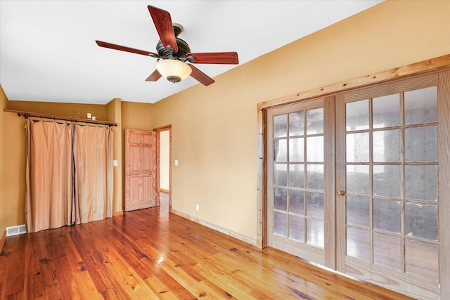 unfurnished room featuring visible vents, baseboards, light wood-style floors, and a ceiling fan