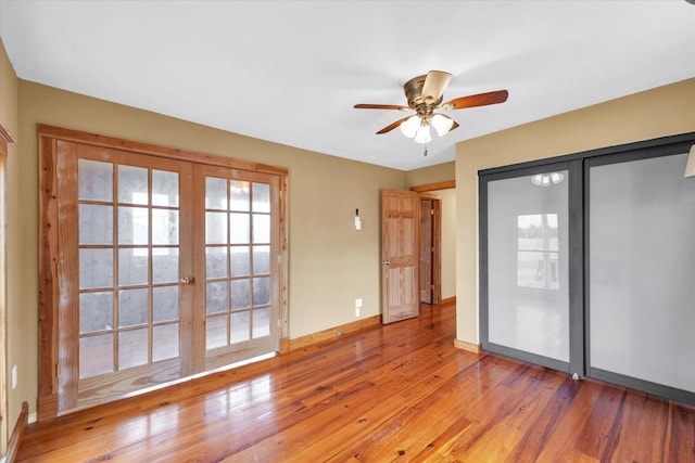 unfurnished room with french doors, baseboards, light wood-style floors, and ceiling fan